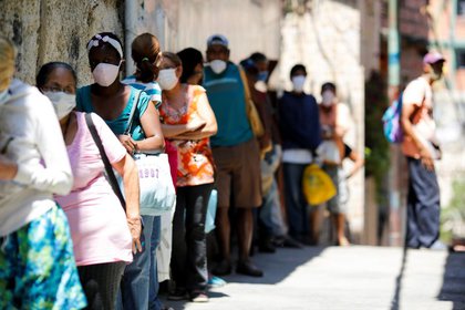 Un grupo de personas haciendo fila para recibir comida de una beneficencia en el barrio de Carapita, en Caracas, en medio de la pandemia de COVID-19 (REUTERS/Manaure Quintero)